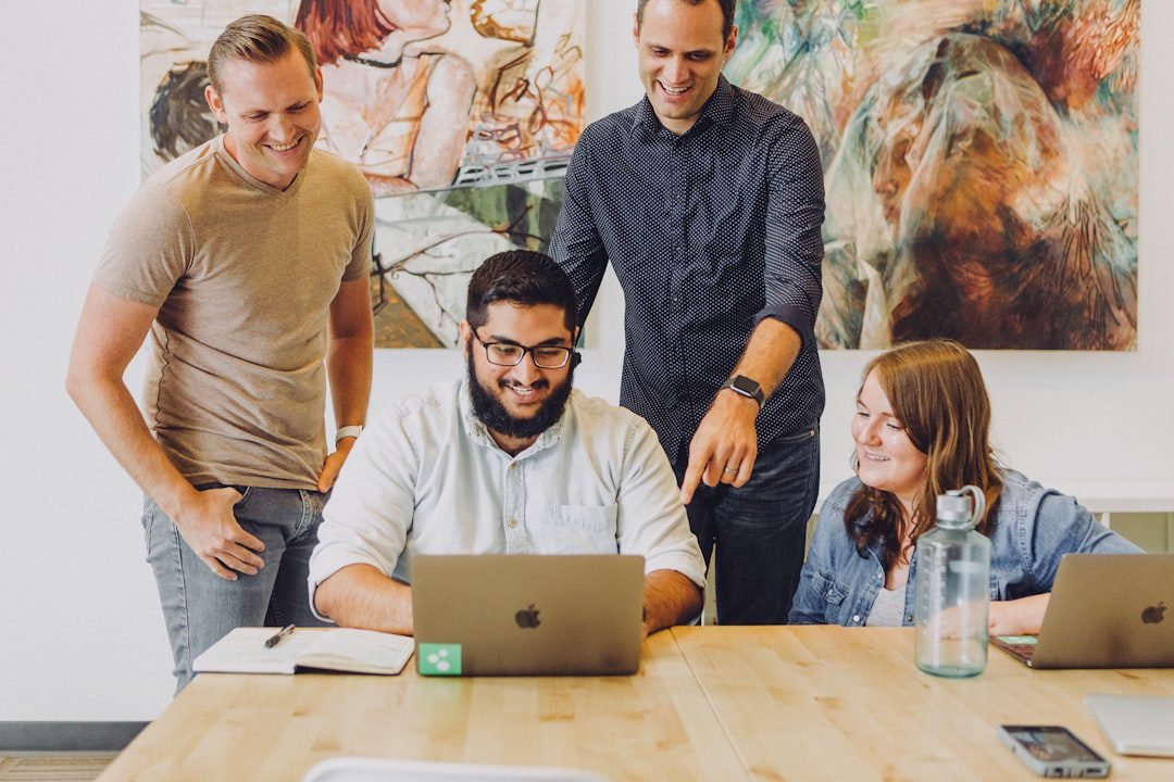 Small team collaborating around laptops in an office